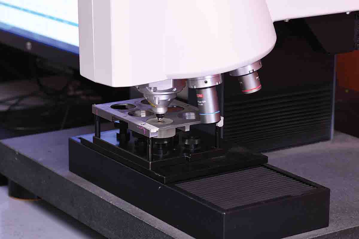 This is a micro hardness tester indenting a test sample. Note the lenses in the turret that can be rotated into position.